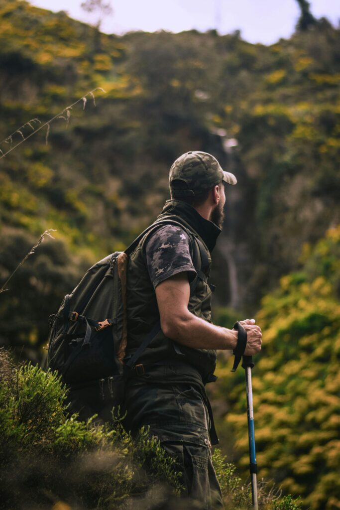 pexels-photo-2108845-2108845 Man with hiking gear explores lush forest landscape, embodying adventure and nature.